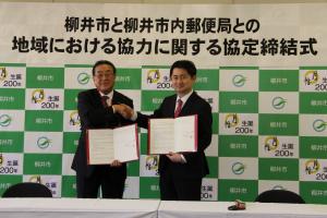 市長と郵便局長代表者との協定書の交換