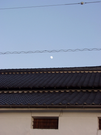 白壁に上る月の写真