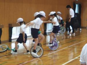 全校体育で一緒に一輪車の練習をする様子