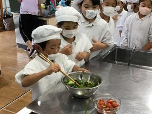 サラダを混ぜる子どもたち