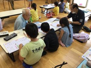 地域の方に勉強を教わる子どもたち