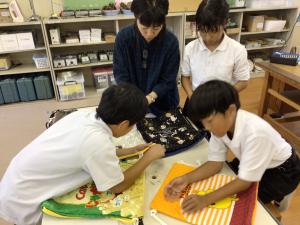 ナップサックにひもを通す子どもたち