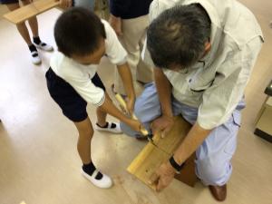 のこぎりで木材を切るところ