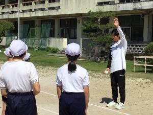 ボールを遠くに投げるコツを教わる子どもたち