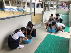 洗い桶で洗濯をする子どもたち