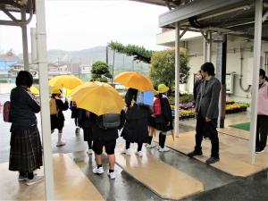 傘をさして
