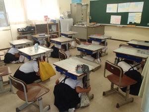 机の下に避難する様子